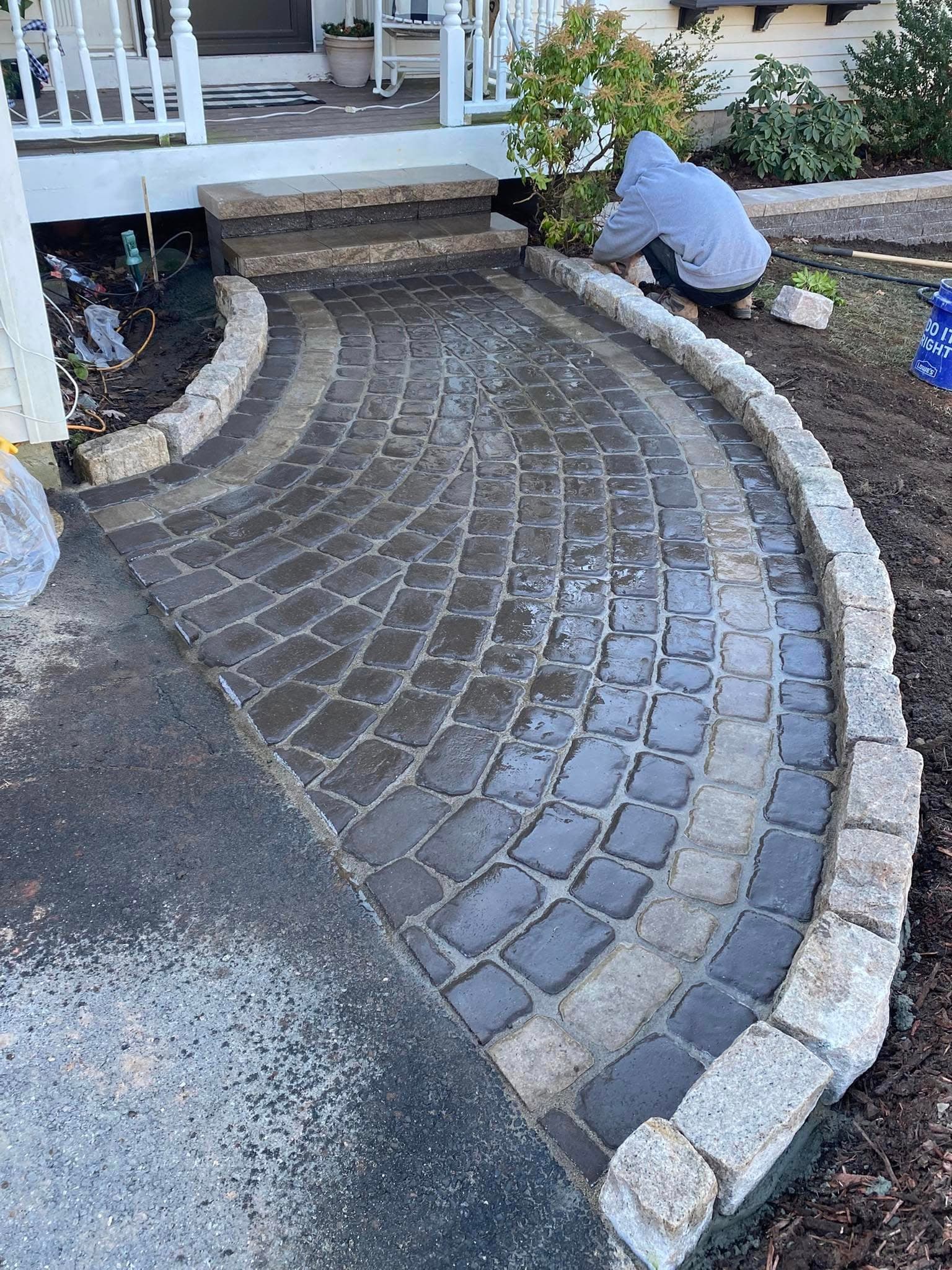 Pete's Lawn Care crew installing custom cobblestone walkway in Southington CT